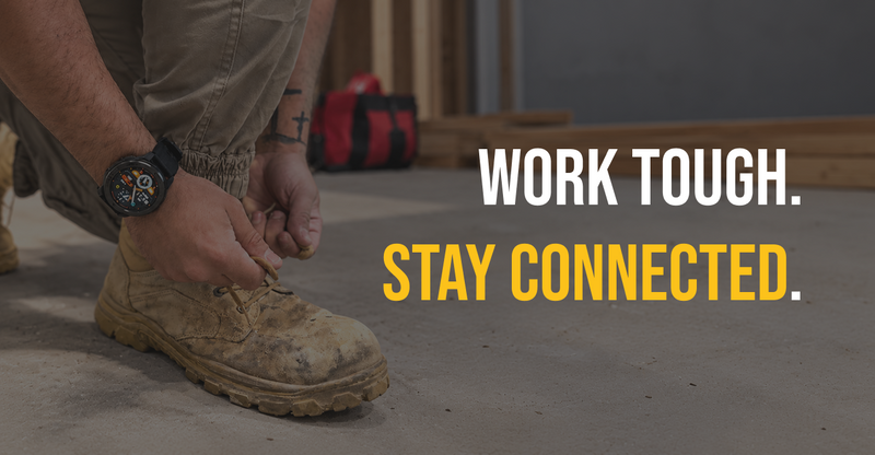A close-up of a person tying the laces of a rugged tan work boot in a workshop setting, with a red tool bag in the background and the text 'WORK TOUGH. STAY CONNECTED.